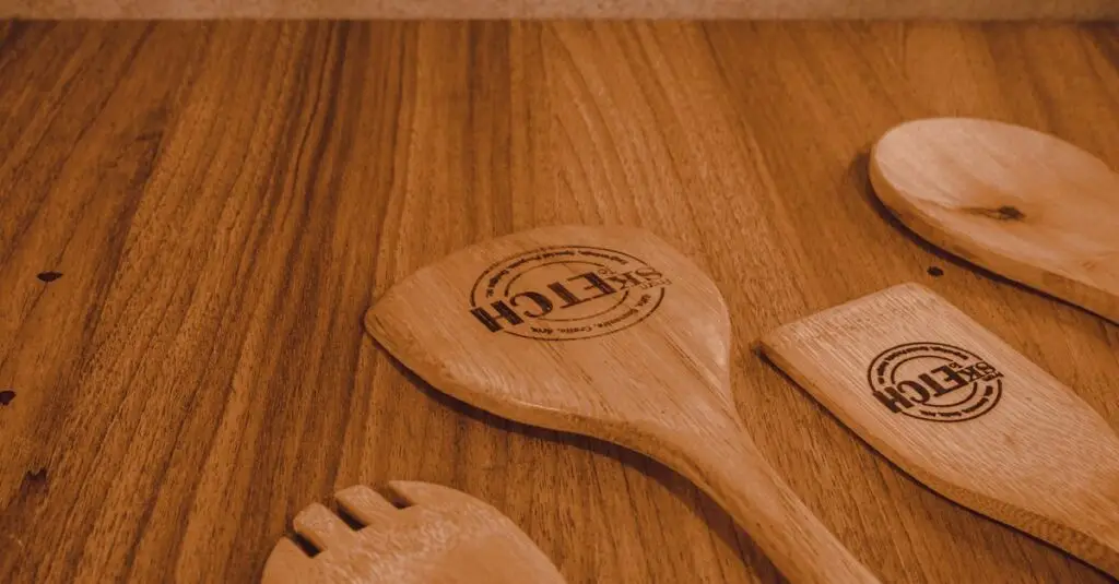 Close-up of wooden kitchen utensils on a rustic wooden surface, perfect for culinary themes.
